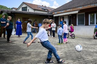 Des réfugiés jouent dans la cour de la maison qui les accueille à Gilly (VD). En tout, trois familles avec 25 enfants et cinq adultes sont accueillies dans ces lieux (archives).